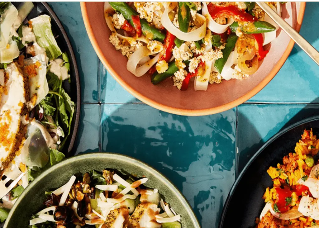A top-down view of different bowls of food on a tile countertop.