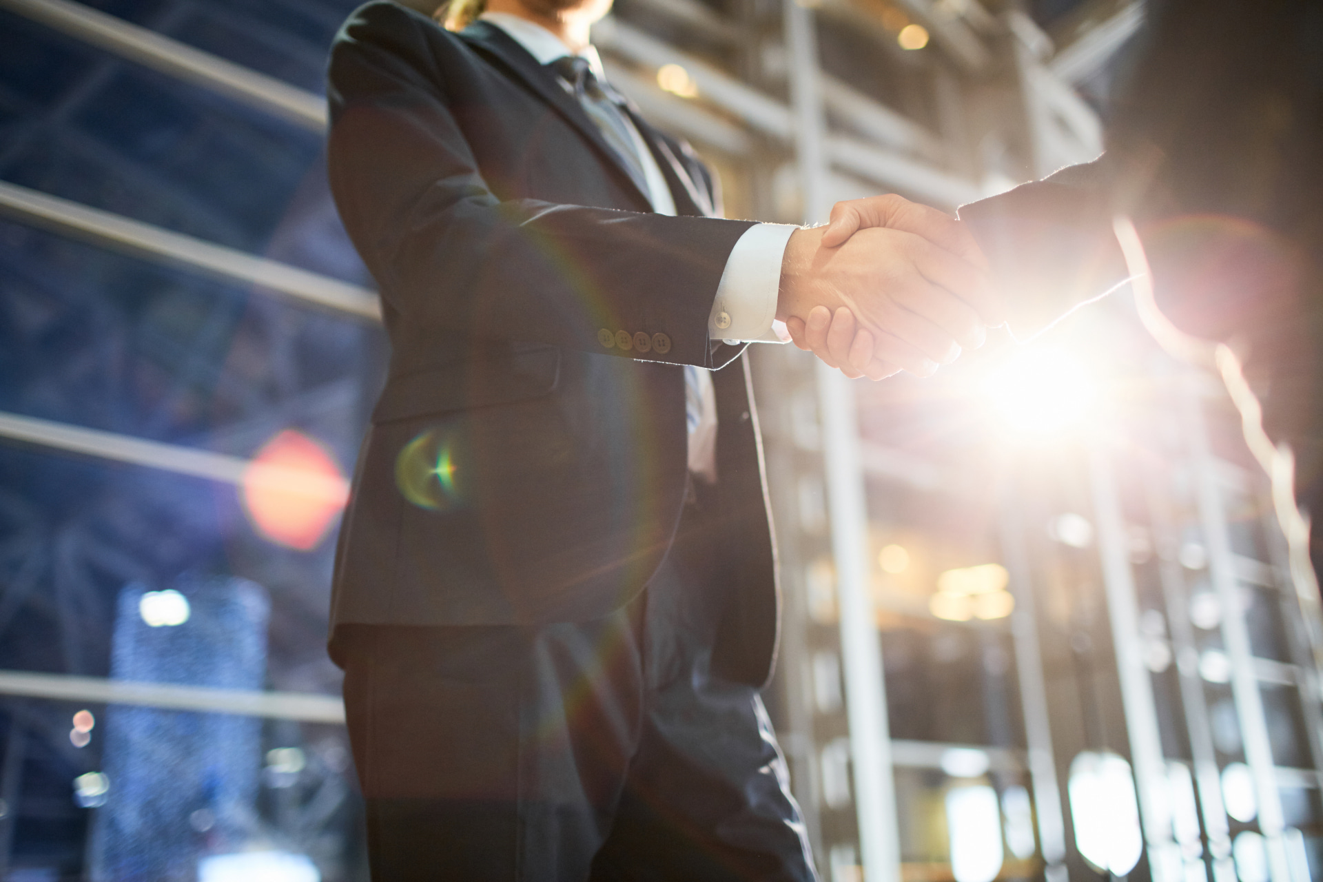 A business broker shakes hands with a client to finish a deal.