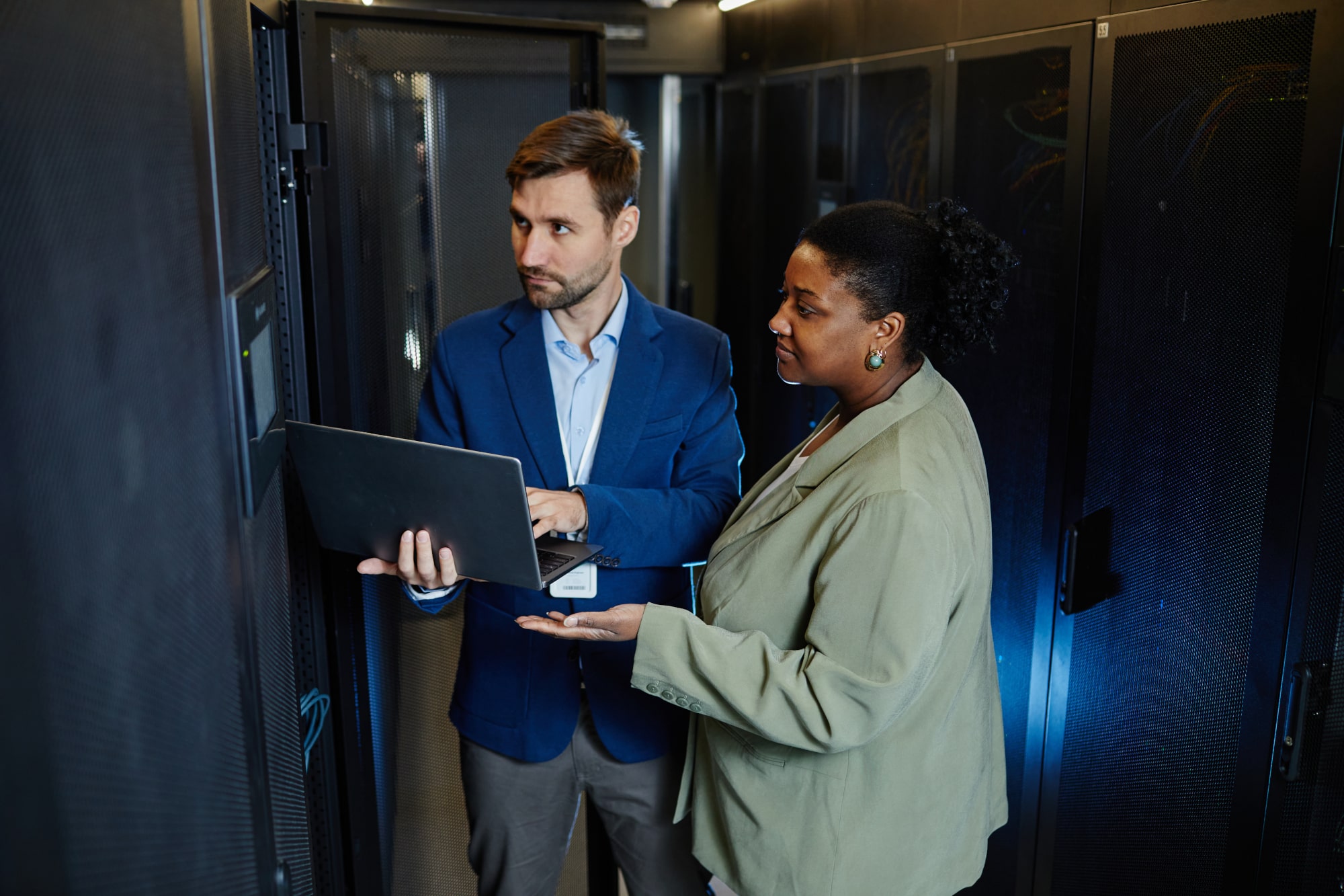 An owner and a broker in a server room having a conversation.